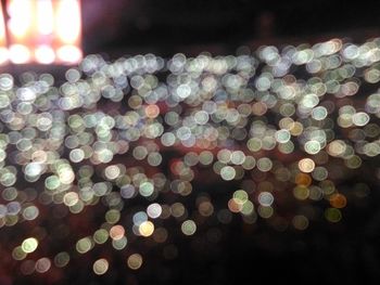 Close-up of illuminated lights against sky at night