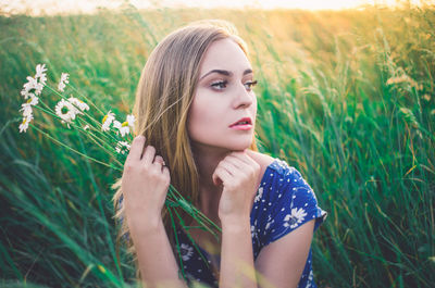 Portrait of beautiful young woman in field