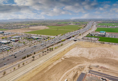 High angle view of road amidst field against sky