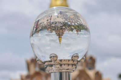 Close-up of crystal ball against sky