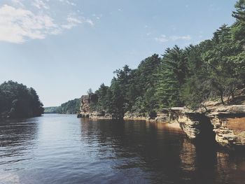 River amidst trees in forest against sky