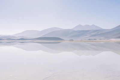 Scenic view of lake by mountains against sky