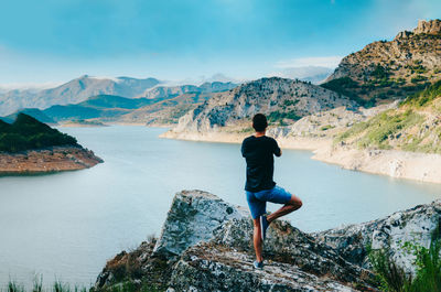 Rear view of woman looking at mountains against sky