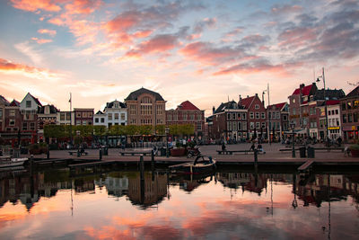 Reflection of buildings in lake at sunset