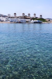 Scenic view of sea by buildings against sky