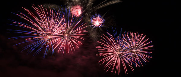 Low angle view of firework display at night