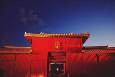 Low angle view of red building against blue sky