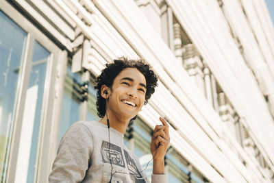 Portrait of smiling young man standing against built structure