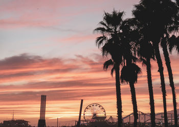 Silhouette palm trees against sky during sunset