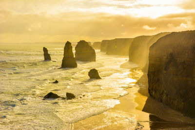 Scenic view of sea against cloudy sky during sunset