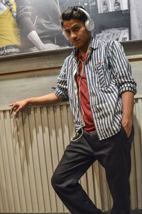 Young man looking away while sitting on railing