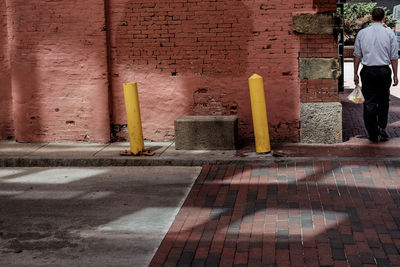 Rear view of man walking by building