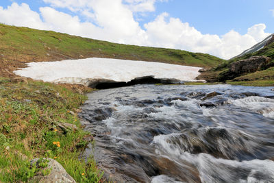 Scenic view of waterfall against sky