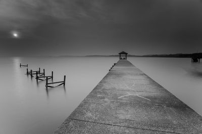 Wooden jetty in lake against sky