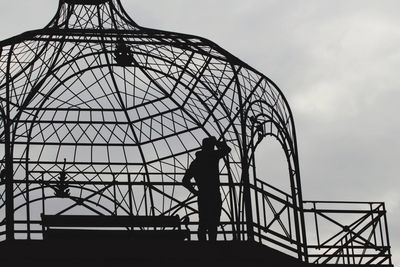 Low angle view of silhouette man standing against sky