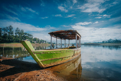 Abandoned boat in lake against sky