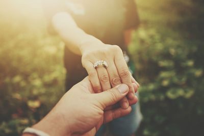 Close-up of man holding hands against blurred background