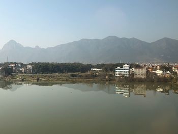 Reflection of buildings in lake against sky