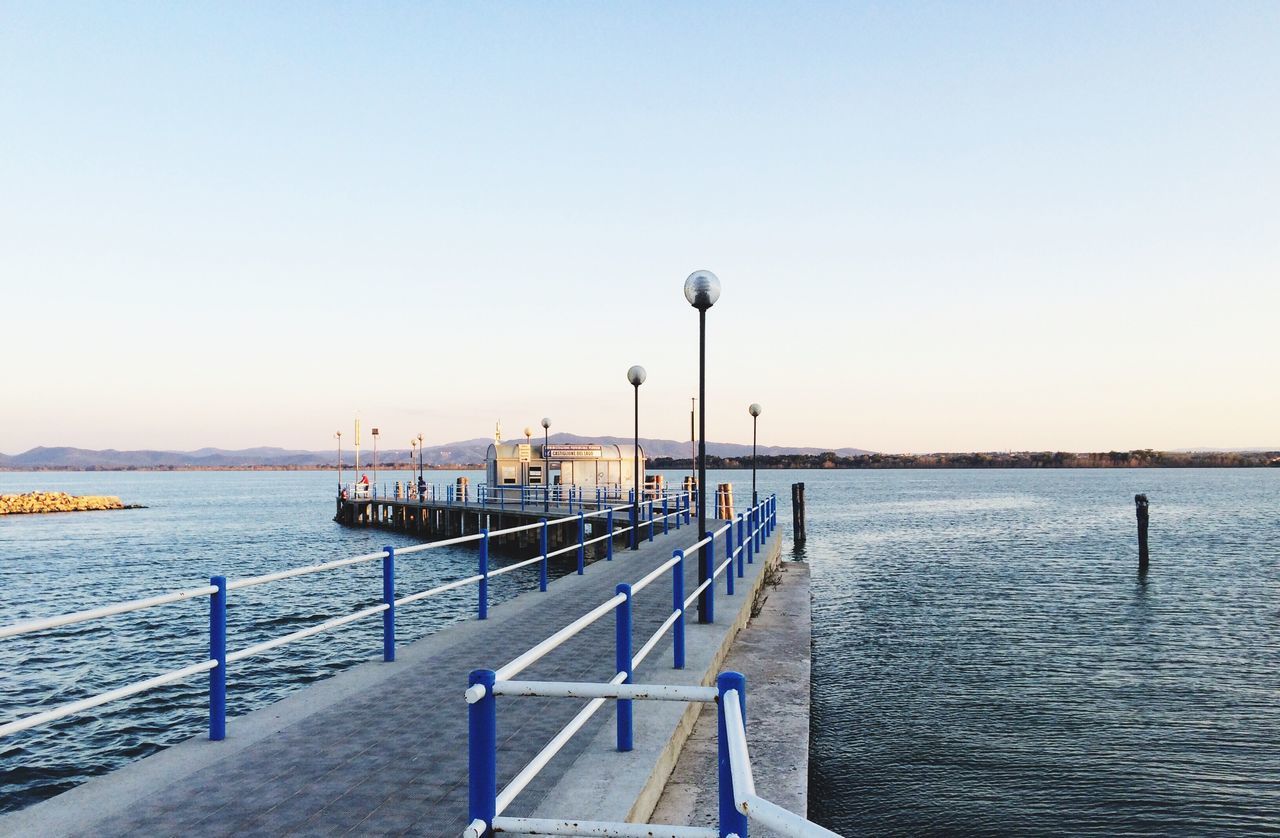 water, sea, pier, clear sky, copy space, street light, tranquil scene, tranquility, pole, rippled, scenics, railing, nature, day, ocean, calm, beauty in nature, outdoors, harbor, seascape, waterfront, lamppost