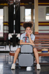 Portrait of young woman sitting on escalator