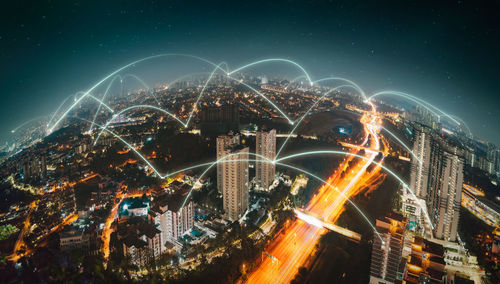 Illuminated cityscape against sky at night