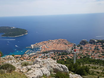 High angle view of townscape by sea against sky