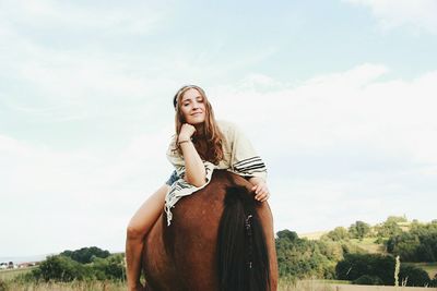 Rear view of woman riding horse backwards