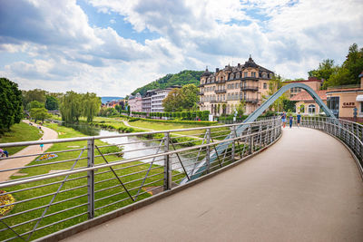 Bridge over river in city against sky