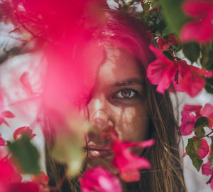 Portrait of young woman by pink flowers at park