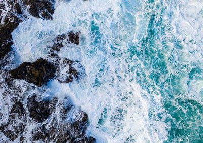 Full frame shot of sea waves splashing on rocks