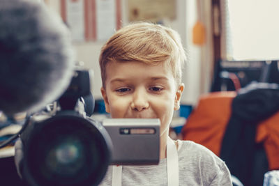 Portrait of boy photographing through smart phone