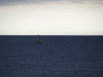 Sailboat sailing on sea against sky