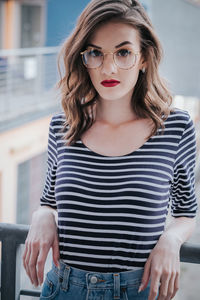 Portrait of beautiful young woman leaning on railing