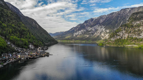 Scenic view of lake by mountains against sky