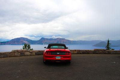 Vintage car on road by mountains against sky