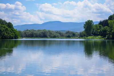 Scenic view of lake by trees against sky