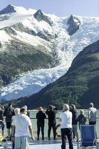 Rear view of people walking on snowcapped mountain