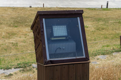 Close-up of old telephone booth on field