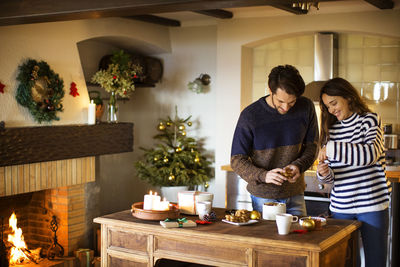 Smiling couple decorating home during christmas