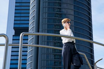 Low angle view of woman standing against building