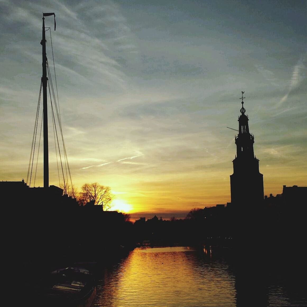 sunset, silhouette, architecture, built structure, sky, orange color, building exterior, water, waterfront, river, cloud - sky, sun, connection, reflection, scenics, cloud, beauty in nature, nature, outdoors, no people