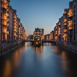 Illuminated buildings against sky at night