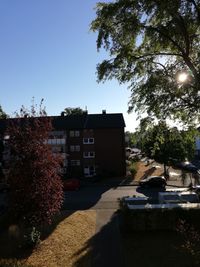 Houses and trees against sky in city