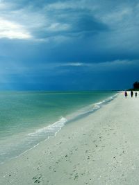 Scenic view of beach against cloudy sky