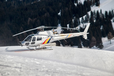 A silver rescue helicopter of the mountain rescue service waiting for mission snowcovered heliport