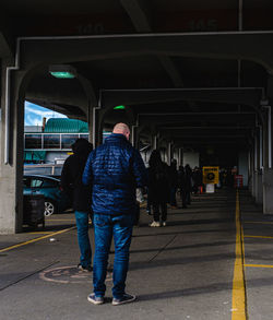 Rear view of people walking on road