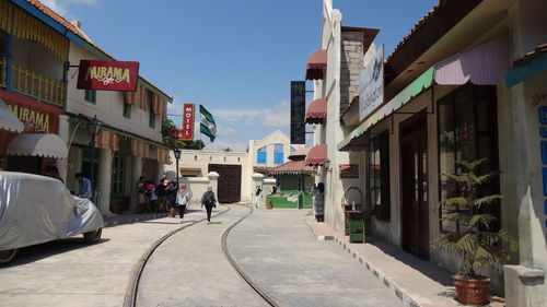 Street amidst buildings against sky in city