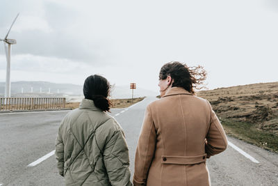 Rear view of females standing on road