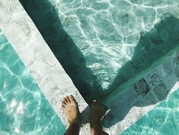 Low section of person by swimming pool in sea
