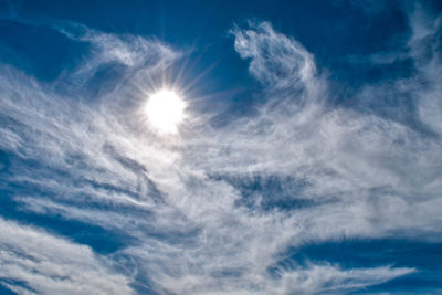 Low angle view of bright sun in sky